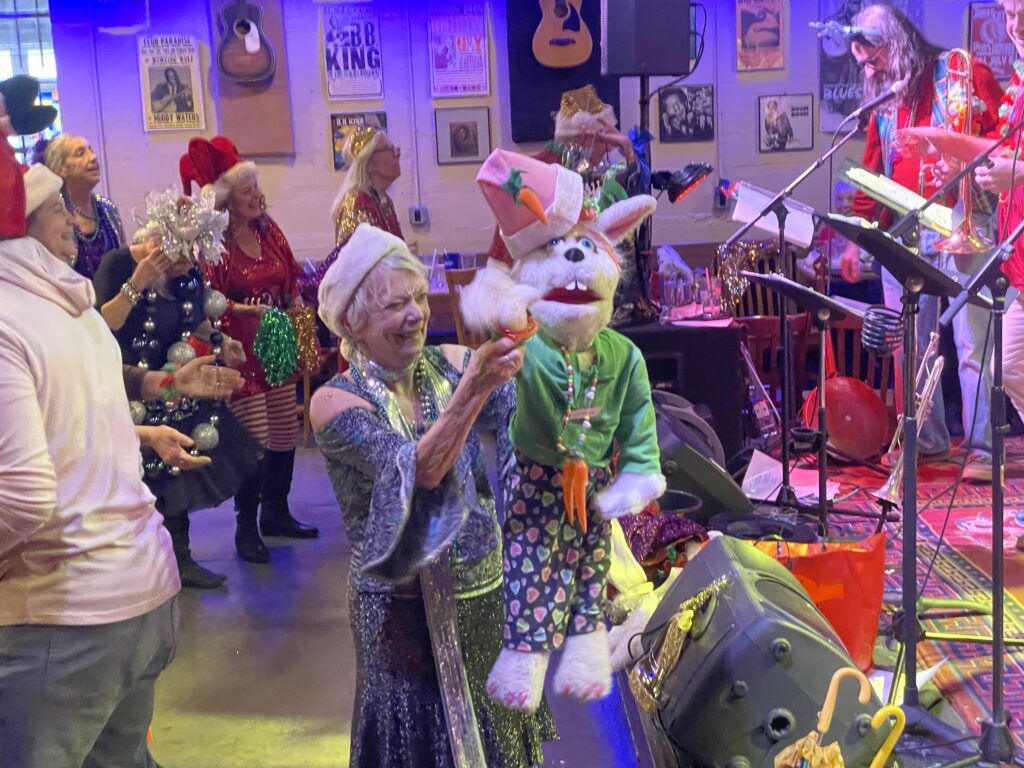 Cathy dancing in the crowd with a puppet